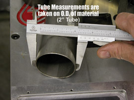 A person measuring a tube's diameter